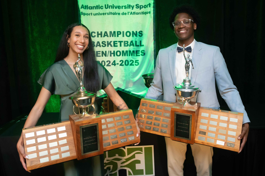 photo of woman and man holding large trophies