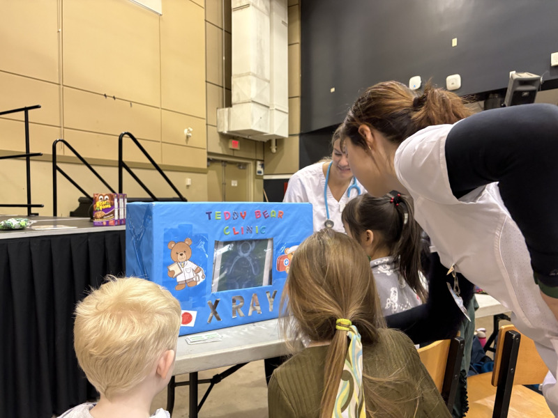 Nursing students Sarah Gard and Hannah MacDonald x-ray stuffed toys at the teddy bear clinic as their young owners look on. Teddy bear clinic
