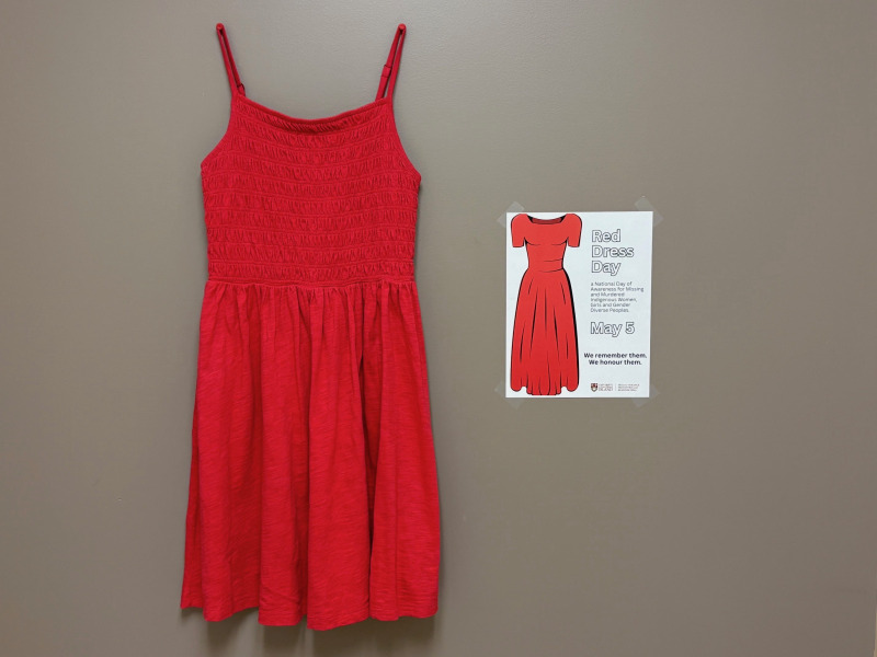 photo of a red dress and a poster hanging on a wall