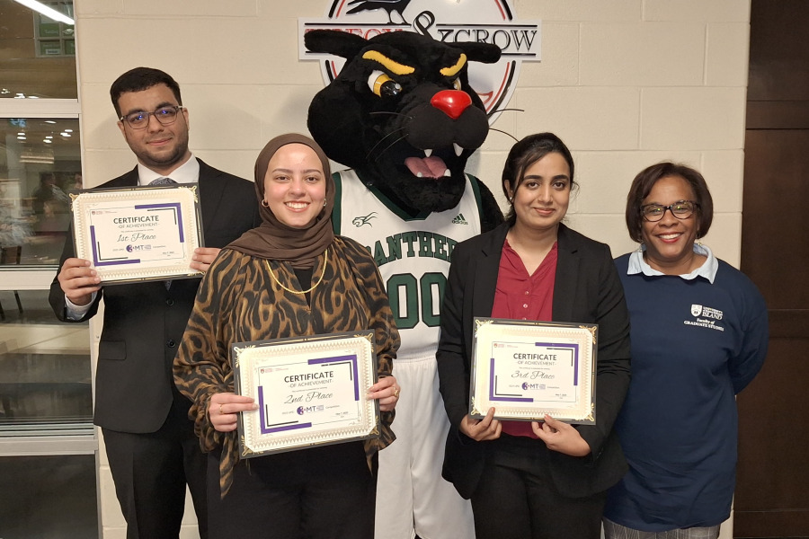 Dr. Marva Sweeney-Nixon (right), UPEI Associate Vice-President, Research, and Dean, Graduate Studies, congratulates the winners of the recent UPEI 3-Minute Thesis competition. Soroush Izadan (left) won first place; Fairouz Gaballa (second from left), second place, and Fatima Imtiaz (second from right), third place. Looking on is Pride, the UPEI mascot. 3-Minute Thesis winners