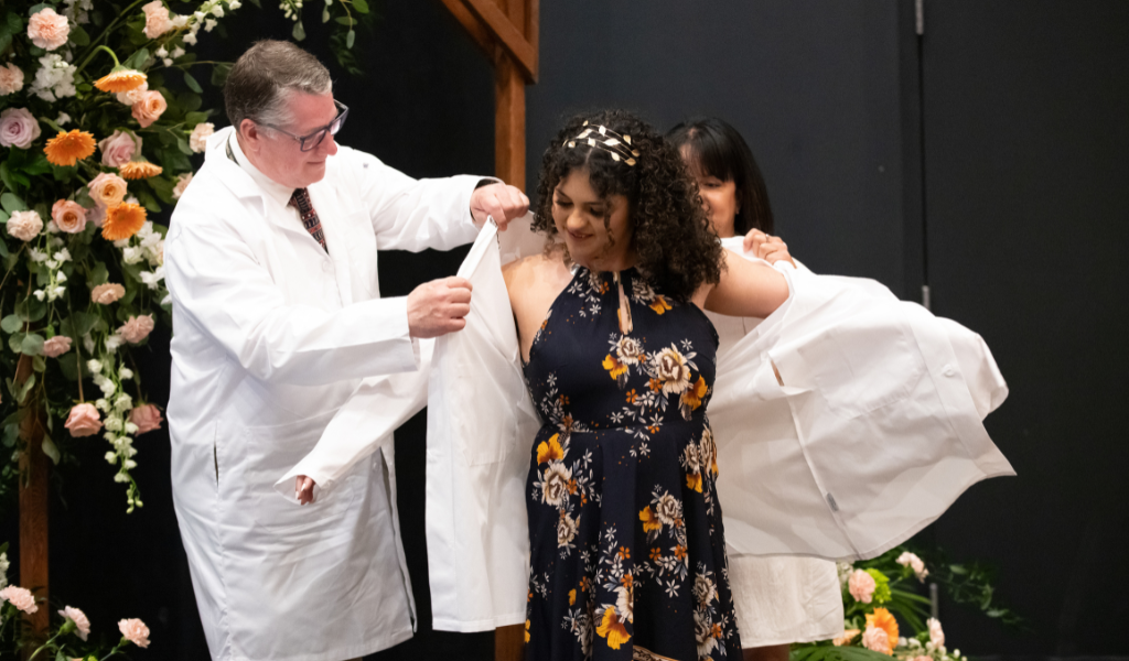 Dr. Alondra Crespo-Rivera (centre) receives her white coat from AVC’s Dr. Patrick Burns (left) and her mother, Sonylma Rivera (right). Dr. Alondra Crespo-Rivera (centre) receives her white coat from AVC’s Dr. Patrick Burns (left) and her mother, Sonylma Rivera (right).