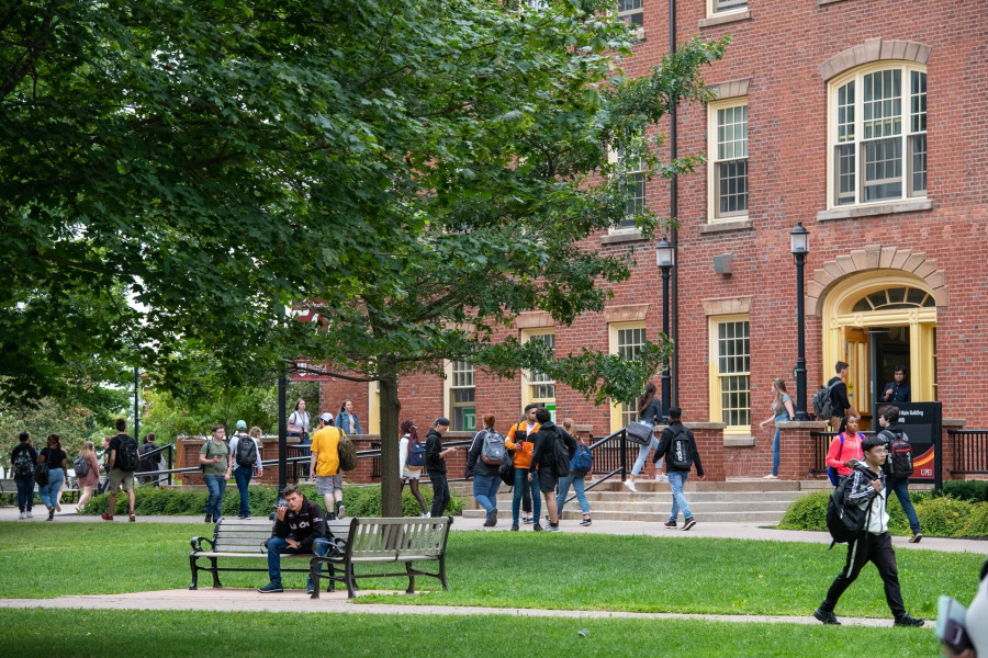 Photo of students walking and entering building on campus