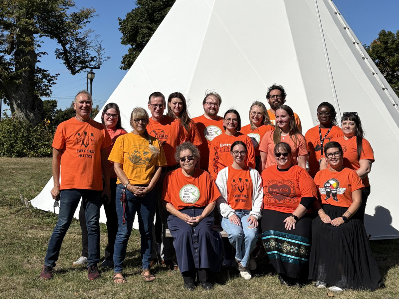 photo of people in front of a tipi