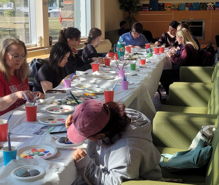 Participants in the Scatter Stones event paint rocks with messages of respect, consent, compassion, and care. Participants in the Scatter Stones event paint rocks with messages of respect, consent, compassion, and care.