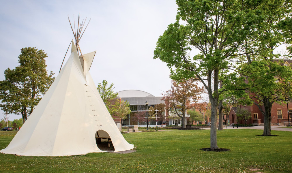 Photo of tip in front of brick buildings on campus