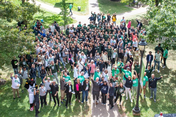 photo of a large group of people standing in the quadrangle cheering