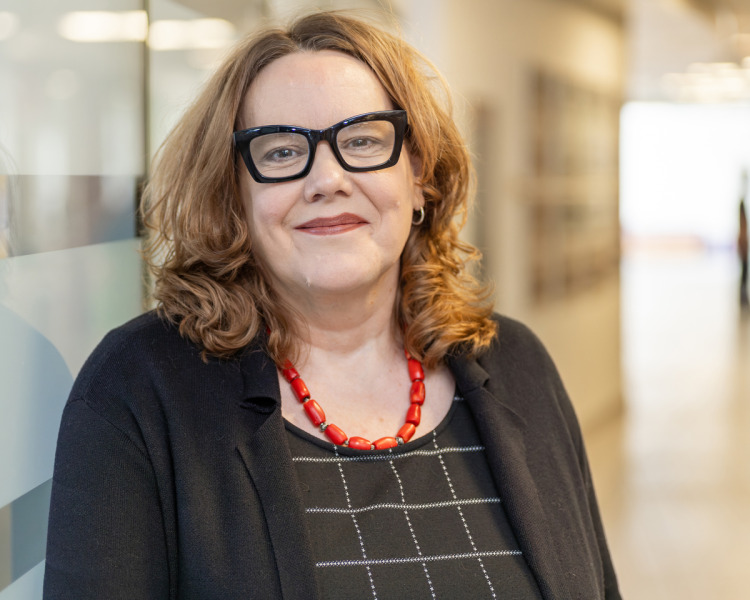 photo of woman wearing glasses in front of a glass wall