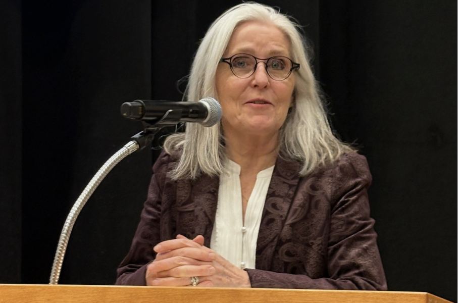 photo of woman wearing glasses speaking from a podium