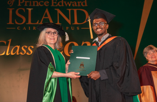 image of woman presenting a degree to a graduating student