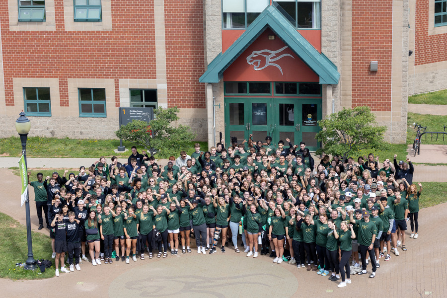 Large group of student-athletes gathered in front of the Sports Centre