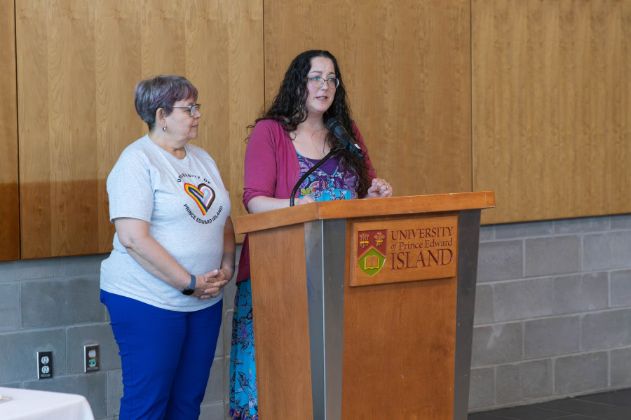 Two women standing at a lectern, delivering remarks
