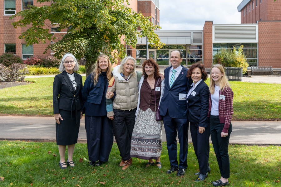 Photo of group of people standing outside in front of a brick building