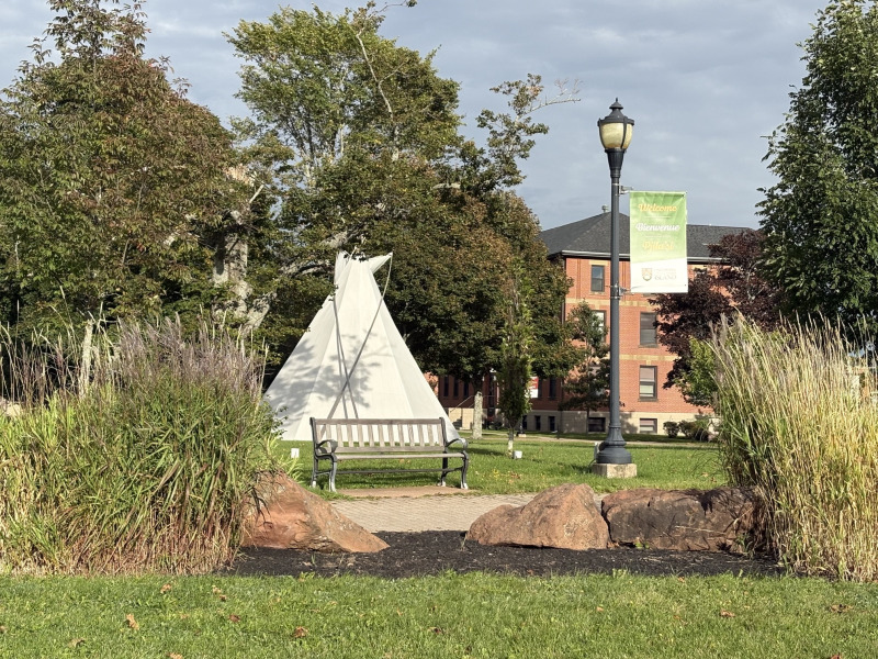 photo of the University's quadrangle including the Tipi and a lamppost and banner