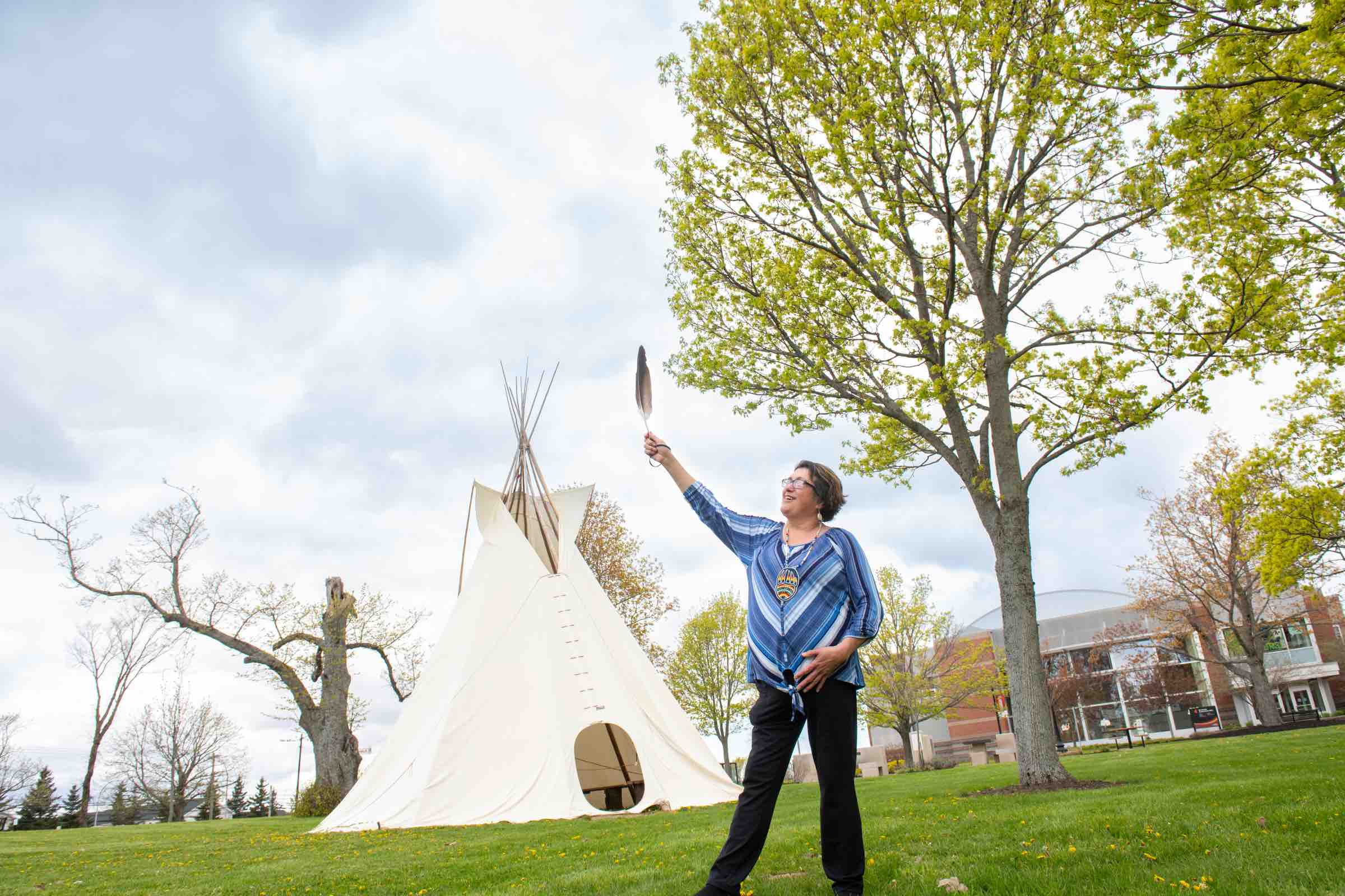 Indigenous language instructor Doris Googoo holding an eagle feather