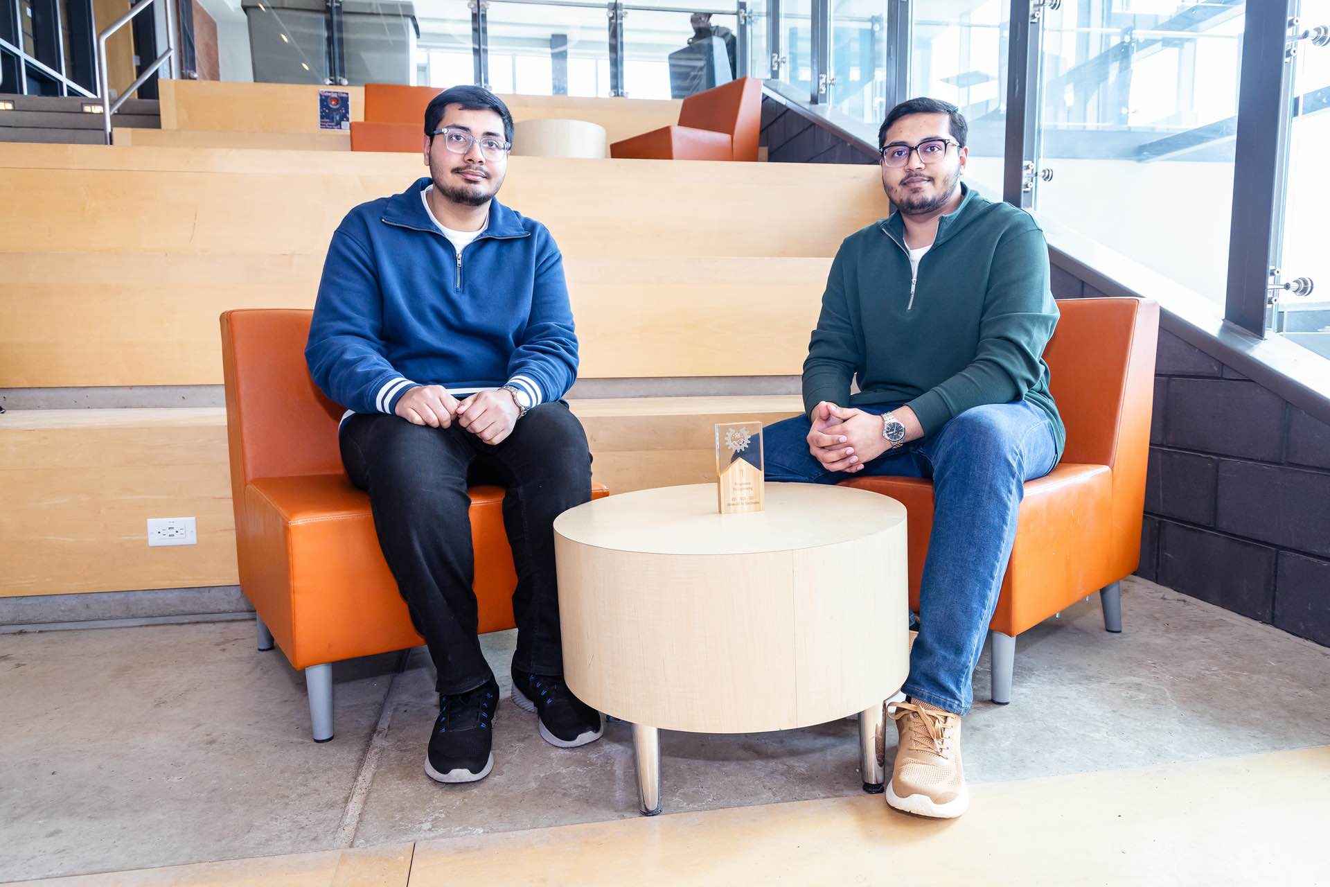 UPEI engineering students Syed Imran Ali and Syed Daniyal Ali sitting in a lit building atrium
