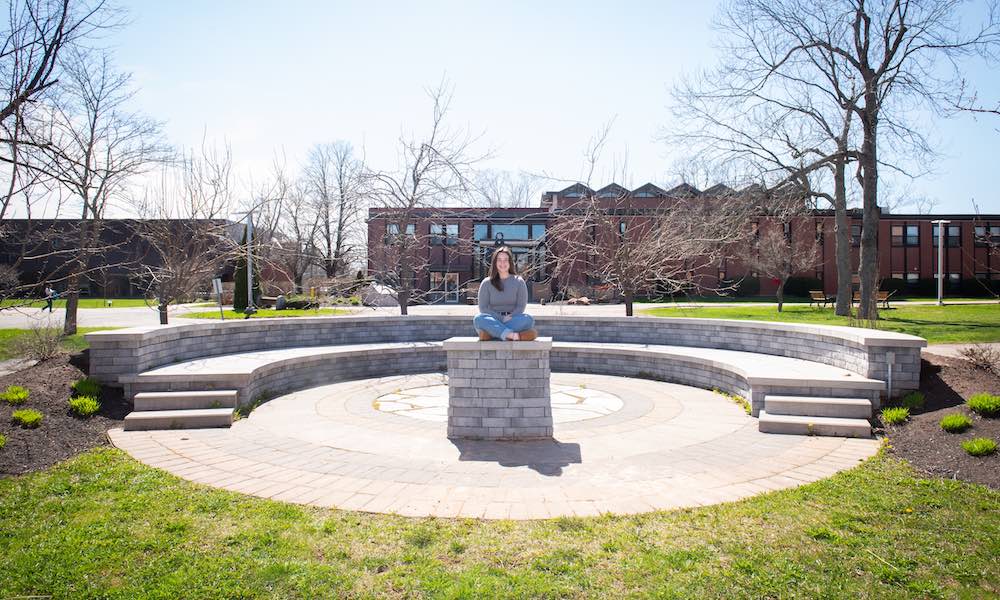 UPEI student Annika Masters in the stone theatre outside the Chaplaincy Centre