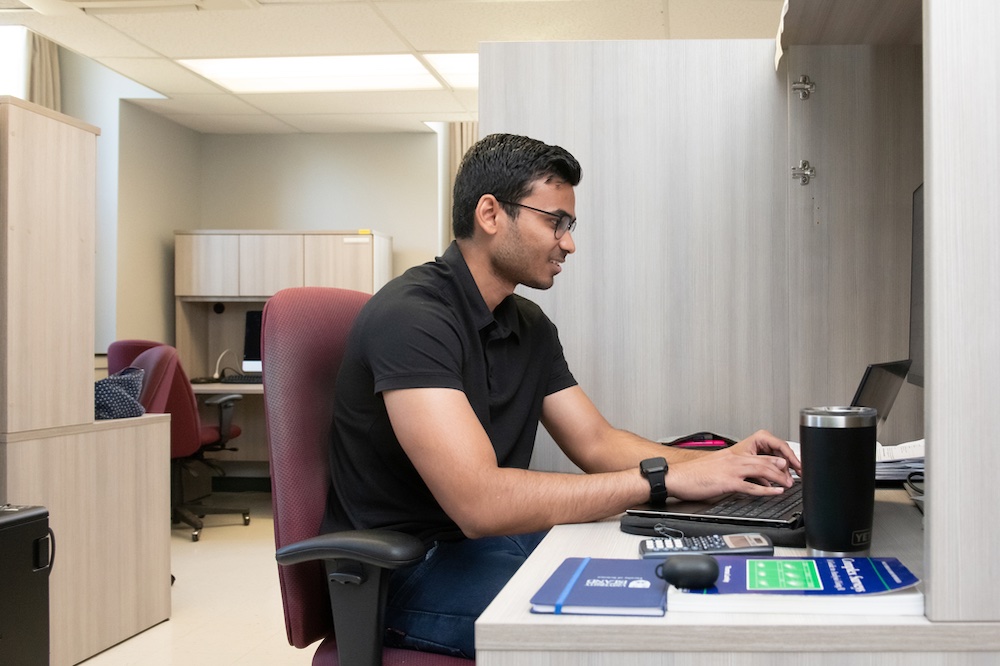 UPEI graduate student Aadesh Nunkoo at a computer