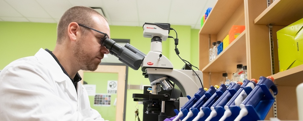 Dr. Jay Penney looking through a microscope