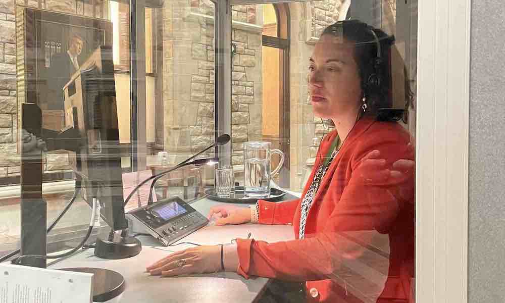 Deidre Kelly wearing headphones, working at Parliament Hill