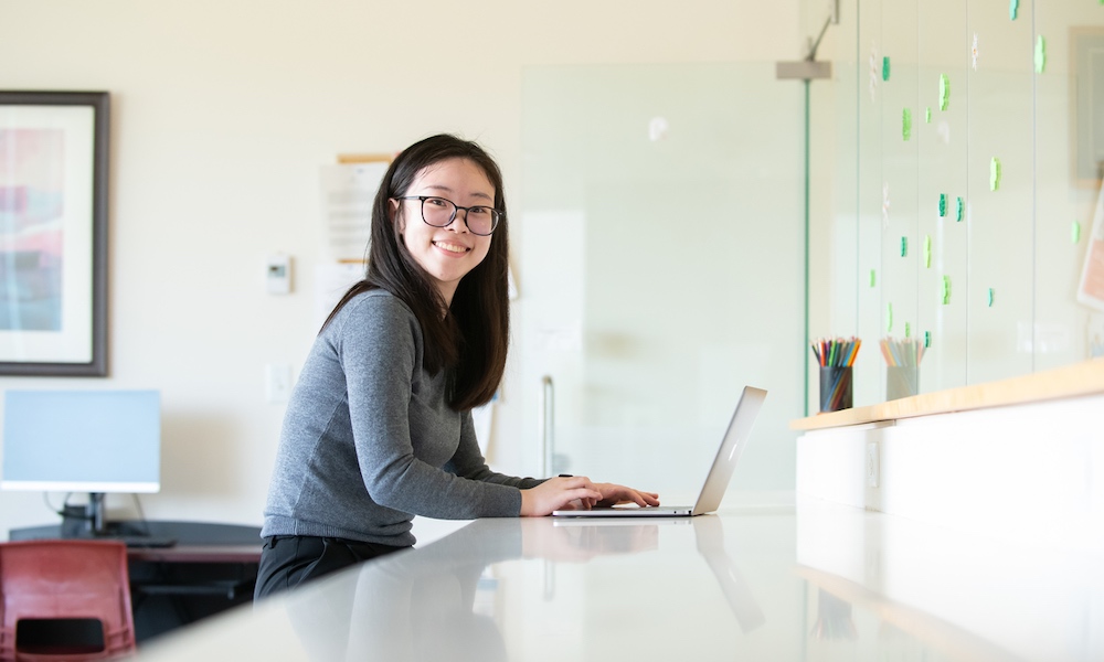 UPEI student EeVon Lim in a lab with a laptop