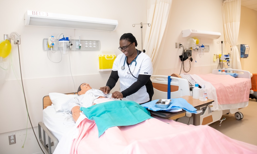 a nursing student working with a mannequin patient