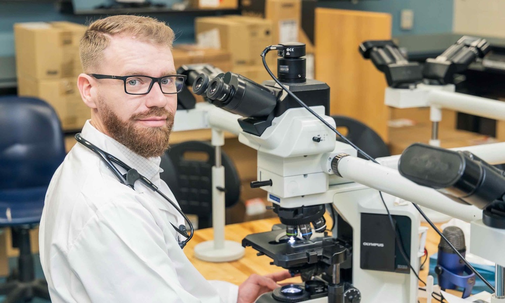 Dr. Will Robbins using a microscope