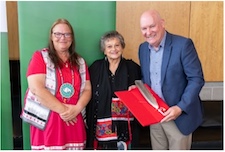 three people with an eagle feather