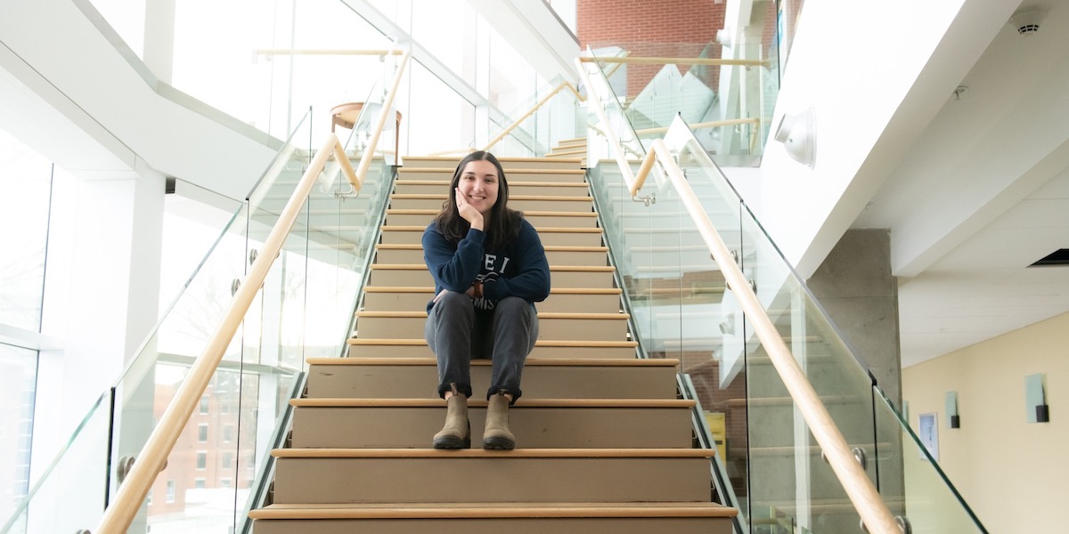 upei chemistry graduate maggie leclair sitting on the stairs of the health sciences building