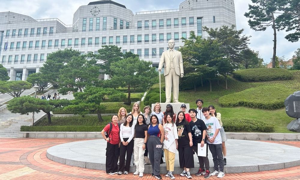 students in front of a statue and a large building at Dankook University, South Korea