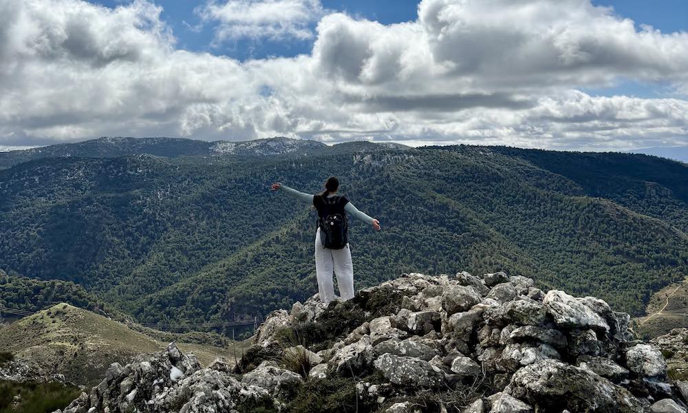 UPEI student Jessika Alkablan on a hill with mountains in the background