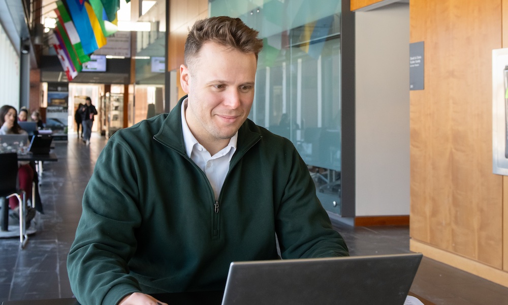a business student on a computer in UPEI's Schurman Market Street