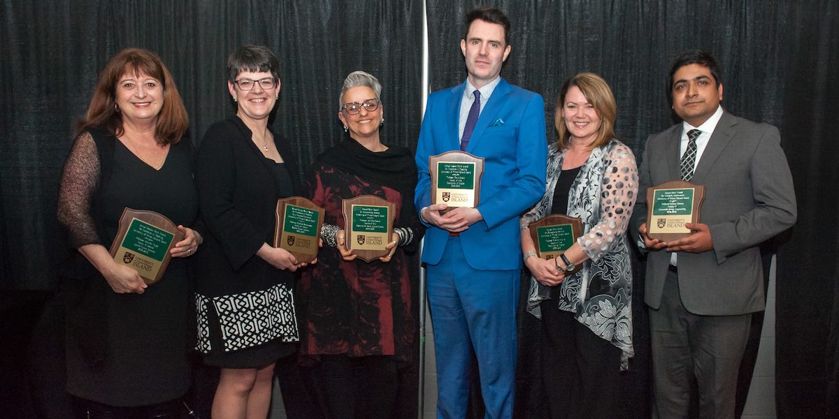 six UPEI faculty members holding award plaques