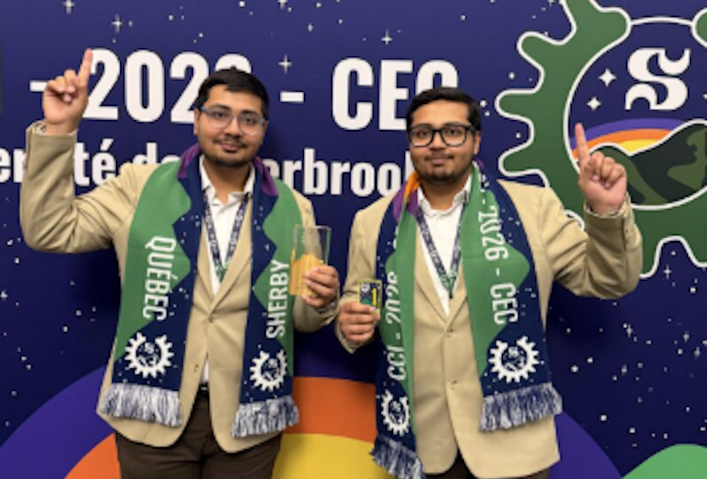 two students posing with an award