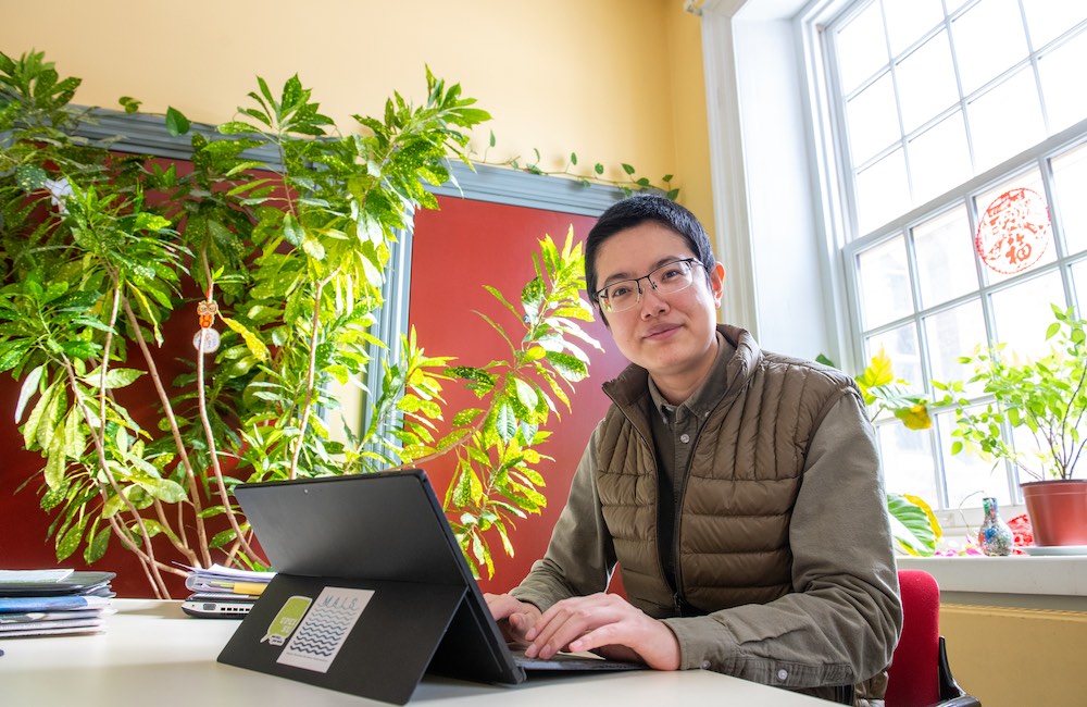 MAIS student Hexi Wang working in a student lounge