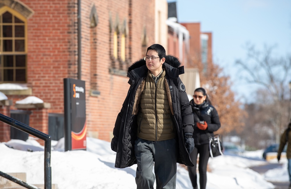 MAIS student Hexi Wang walking to class in the UPEI quad
