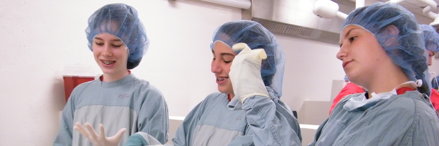 three vetcamp participants wearing surgical gowns