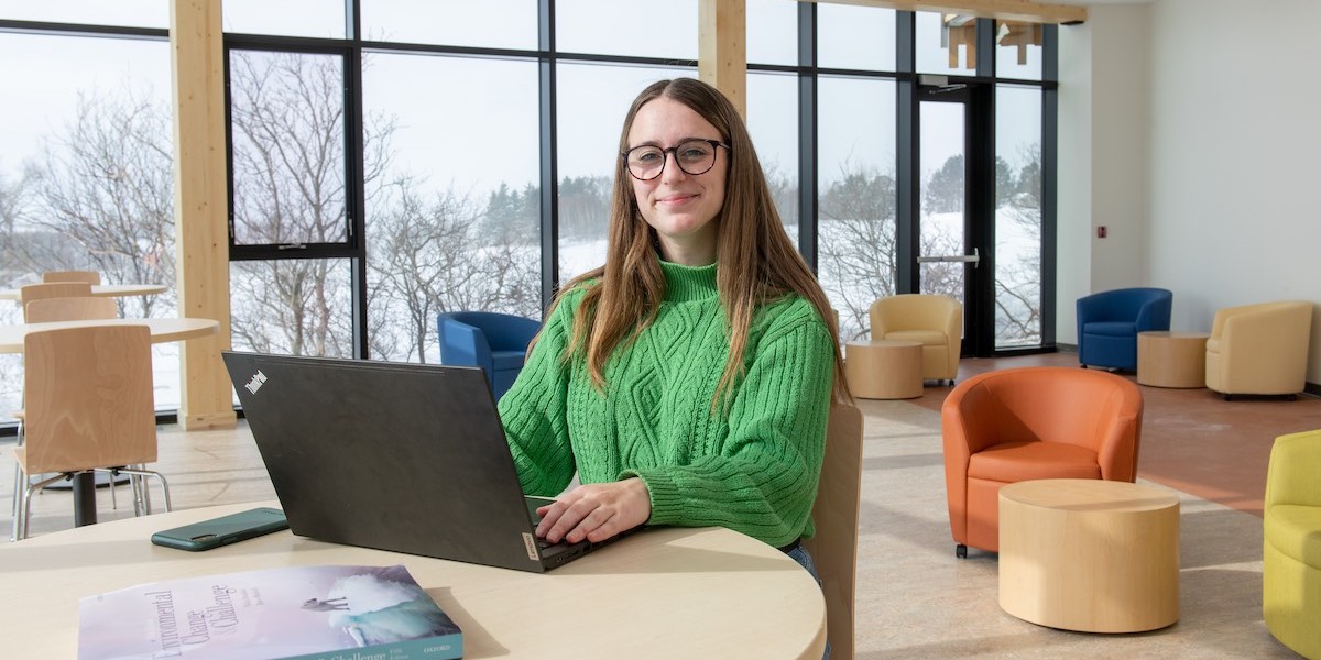 upei climate change student zoe furlotte working at a computer with bright windows in the background