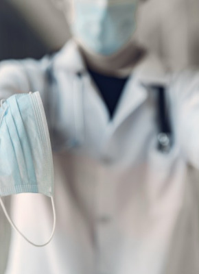 image of person holding mask, sanitizer