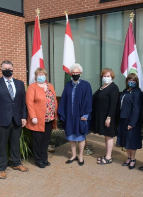Ms. Samantha MacLean, President, UPEI Student Union; The Honourable Dennis King, Premier of Prince Edward Island; Dr. Margaret Steele, MD, Dean of the Faculty of Medicine, Memorial University of Newfoundland; The Honourable Catherine Callbeck, UPEI Chancellor; Ms. Marilyn Barrett, Director of the UPEI Health and Wellness Centre; Dr. Jo-Ann MacDonald, Dean of Nursing (Interim), UPEI; Dr. Greg Keefe, Dean of Veterinary Medicine, Atlantic Veterinary College, UPEI; Dr. Alaa Abd-El-Aziz, UPEI President and Vice-Chancellor A group photo of men and women standing in front of an array of flags from PEI and Canada