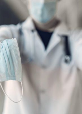 Photo of person holding masks and sanitizer