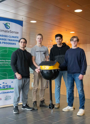 four students standing with a data buoy they created 