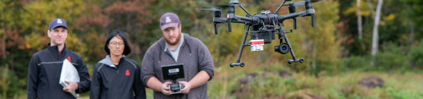 three technicians flying drone quadcopter