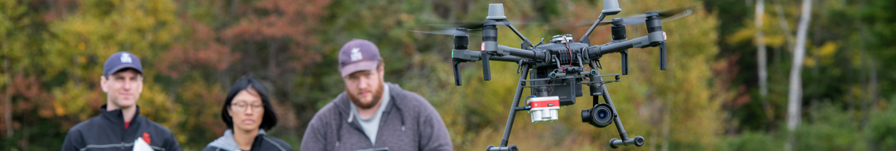 three technicians flying drone quadcopter