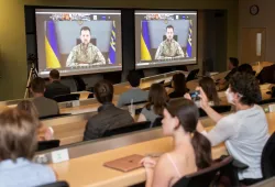 image of students in classroom watching two screens