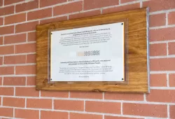 photo of plaque hanging on brick wall