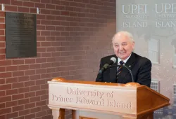 photo of man smiling and standing at a podium