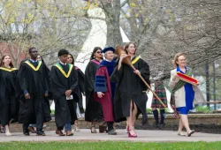 Marshal, Sue Dawson; Macebearer, Shanelle Berthier, Faculty of Science; and Eagle Feather Bearer, Erin Reid, assistant professor, Faculty of Indigenous Knowledge, Education, Research, and Applied Studies, lead graduates in the Faculty of Science into the Chi-Wan Young Sports Centre for their Convocation ceremony on May 16. 