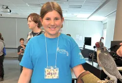 Camper Averie holds a falcon during Vet Camp
