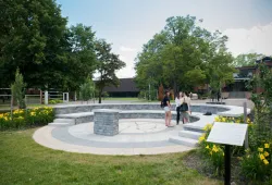 Photo of three students standing in an outdoor amphitheatre on campus