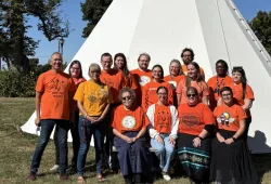 photo of people in front of a tipi
